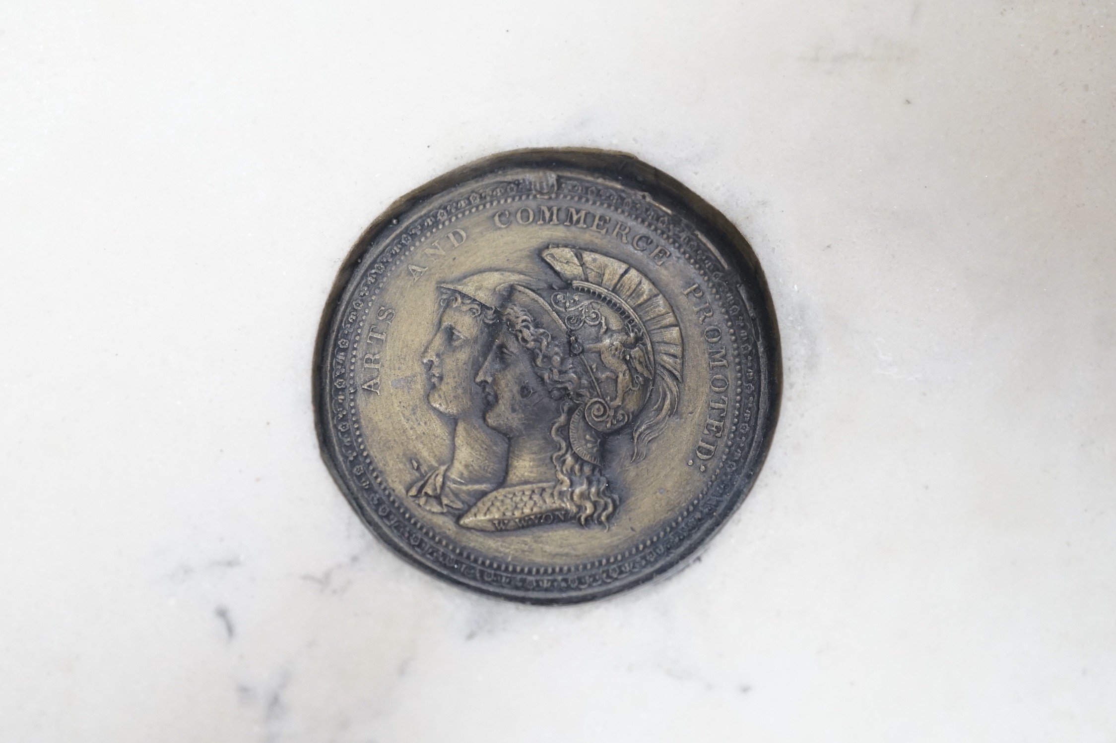 A reproduction reconstituted marble oval plaque with inset coin to reverse, 30cm